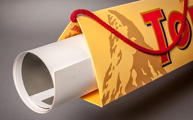 Paper bag with triangular opening and hidden rolled-up poster